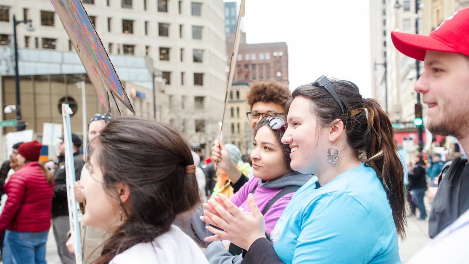 Young people gather with handmade signs at a May Day rally in downtown Milwaukee.